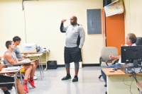 Miami Sunset Senior High School students and Buck Martinez (right), president and founder of Student ACES, listen to Mandrell Nickel, Miami Sunset Senior High School’s football coach, during a recent Student ACES workshop.