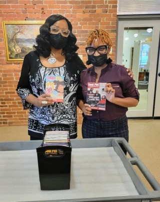 Donna Baxter Porcher, Founder/CEO of Soul Pitt Magazine holds up the 50th edition of Soul Pitt Quarterly while DaNia Childress, Associate Curator for African American History, holds up the very first edition of SPQ.