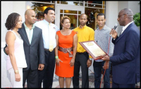 Pictured: The Clayborne family looks on as the late Lowell Hawthorne, CEO of Golden Krust Corporate touts them as the "Franchisees with the Golden Touch." It was later revealed that as Golden Krust deceived the Clayborne's by engaging in practices that si