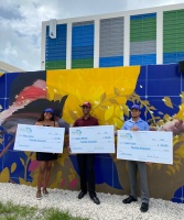 Miya Aviles of Hialeah (left), Jayden McNab of Miramar (center) and Luke Fourie of Homestead (right), proudly hold up their $20,000 college scholarship check from Florida Power & Light Company at its Wynwood Battery in Miami.